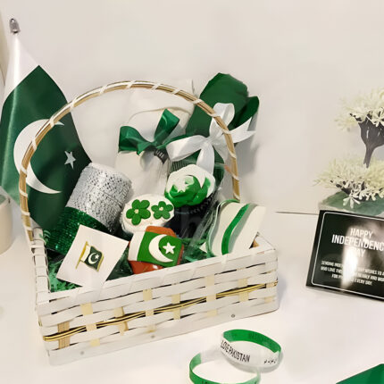 Spirit of Pakistan Hamper featuring patriotic badges, bangles, table flag, cupcakes, men’s polo shirt, wristband, women’s dupatta, all beautifully arranged in a net-wrapped basket – perfect for Independence Day gifting