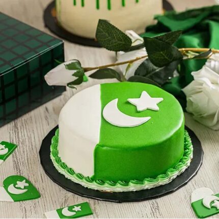 Double Fudge-Flag Cake featuring the Pakistani flag in green and white fondant, with a crescent and star design on top, presented in elegant packaging. Rich chocolate layers visible in the slice, ideal for Independence Day celebrations